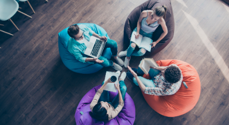 Students sitting in circle with laptops 